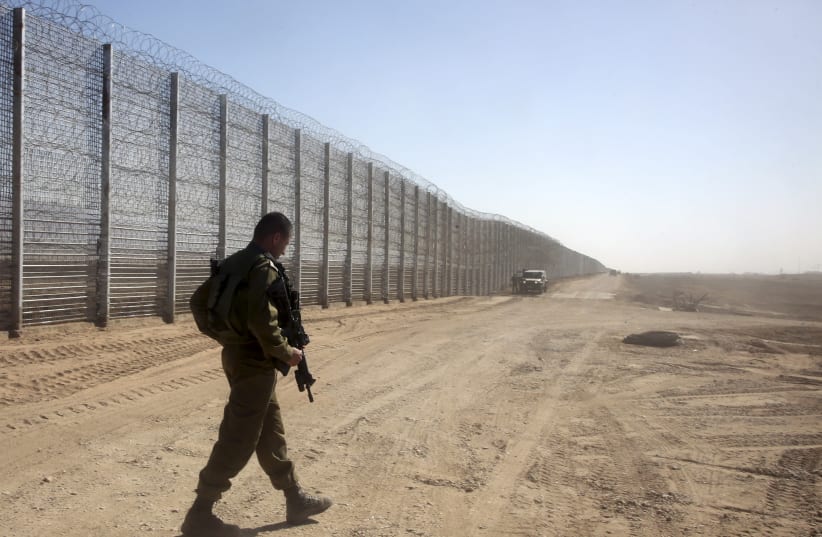 An Israeli soldier walks next to the border fence between Israel and Jordan, in southern Israel near Eilat February 9, 2016. (photo credit: REUTERS/MARC ISRAEL SELLEM)