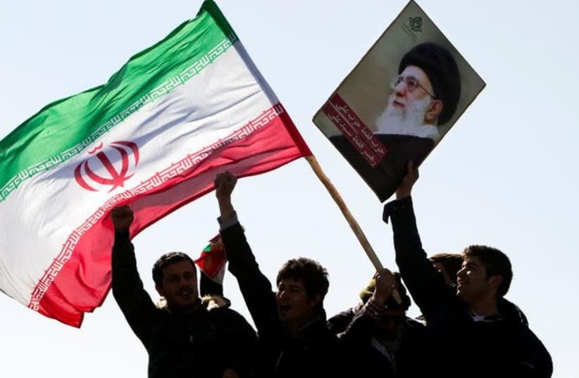 Demonstrators wave Iran's flag and hold up a picture of supreme leader Ayatollah Ali Khamenei during a ceremony to mark the 33rd anniversary of the Islamic Revolution, in Tehran's Azadi square February 11, 2012. (photo credit: REUTERS/RAHEB HOMAVANDI)