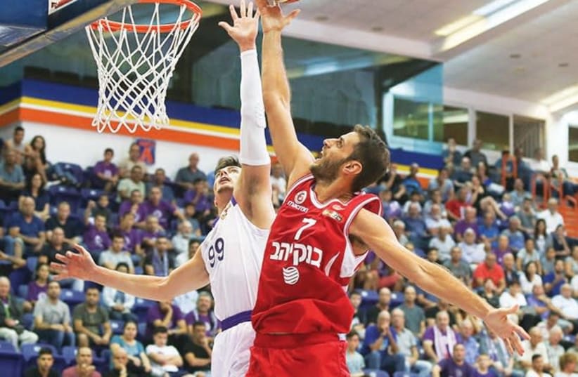 Hapoel Jerusalem’s Greek forward Stratos Perperoglou (right) scores two of his six points during his BSL debut last night, beating Ironi Nahariya’s Yiftach Ziv to the basket in the 76-68 win at Ein Sara. (photo credit: ERAN LUF)