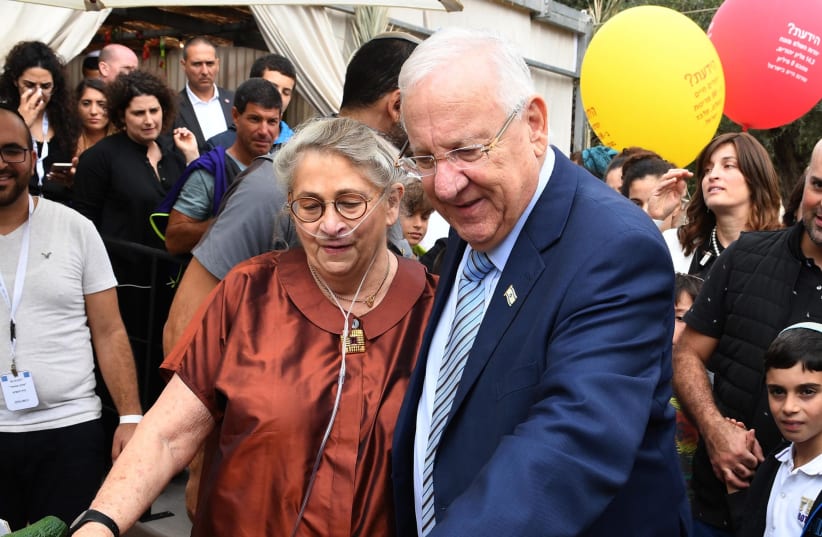 President Rivlin and his wife Nechama greet Israelis in his Jerusalem Sukka. (photo credit: Mark Neiman/GPO)