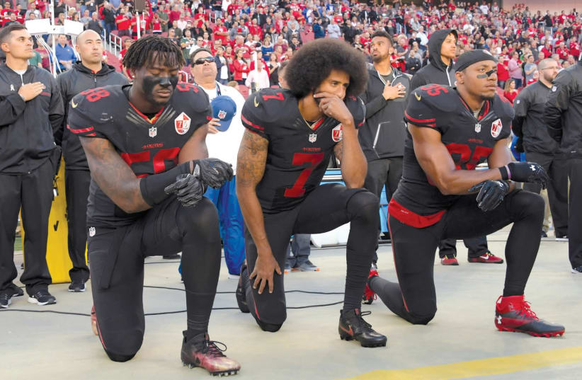 SAN FRANCISCO 49ERS outside linebacker Eli Harold (58), quarterback Colin Kaepernick (7) and free safety Eric Reid (35) kneel in protest during the playing of the national anthem before a NFL game in Santa Clara, California. (photo credit: KIRBY LEE/USA TODAY/VIA REUTERS)