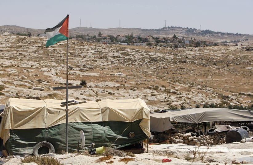 TENTS AND a Palestinian flag at the Beduin community of Susiya (photo credit: REUTERS)