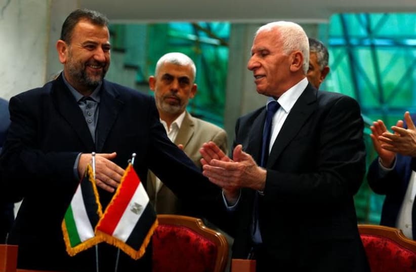 Head of Hamas delegation Saleh Arouri and Fatah leader Azzam Ahmad sign a reconciliation deal in Cairo, Egypt, October 12, 2017. (photo credit: REUTERS/AMR ABDALLAH DALSH)