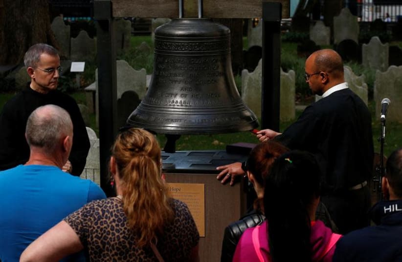 People gather to ring the Bell of Hope, which is rung to remember victims of terrorism and violence around the world, to honour those killed and injured in the Las Vegas mass shooting, at St. Paul's Chapel in New York City, US, October 3, 2017. (photo credit: REUTERS/BRENDAN MCDERMID)