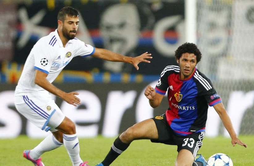 FC Basel's Mohamed Elneny (R) fights for the ball against Maccabi Tel Aviv's Eden Ben Basat during their Champions League play-off first leg soccer match at the St. Jakob Park stadium in Basel August 19, 2015.  (photo credit: REUTERS/ARND WIEGMANN)