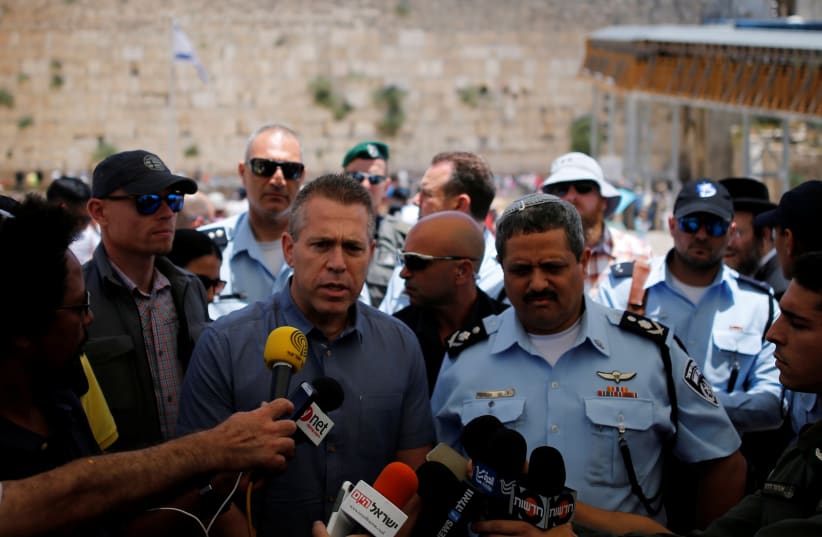 Israel's Public Security Minister Gilad Erdan (3rd L) and police commissioner Roni Alsheich (3rd R) speak to members of the media at the Western Wall in Jerusalem's Old City (photo credit: REUTERS/AMIR COHEN)