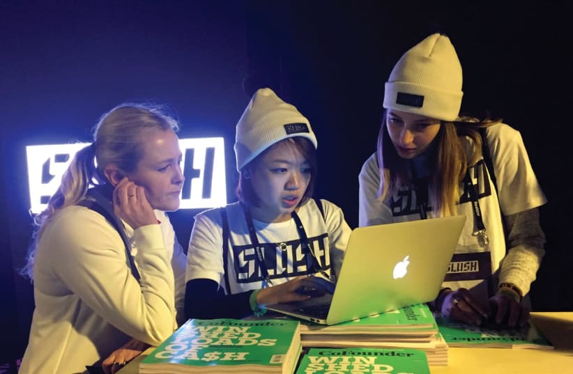 Staff work at Slush, one of Europe’s biggest tech start-up conferences, in Helsinki, Finland, last year. According to Israel’s Central Bureau of Statistics, women make up more than 35% of the nation’s hi-tech workforce. (photo credit: REUTERS)
