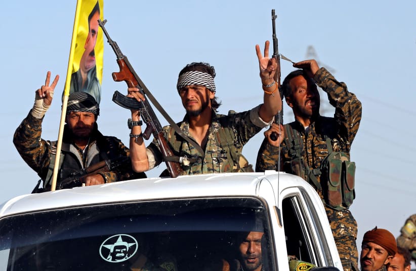 Fighters of Syrian Democratic Forces make the V-sign as their convoy passes in Ain Issa, Syria. (photo credit: REUTERS)
