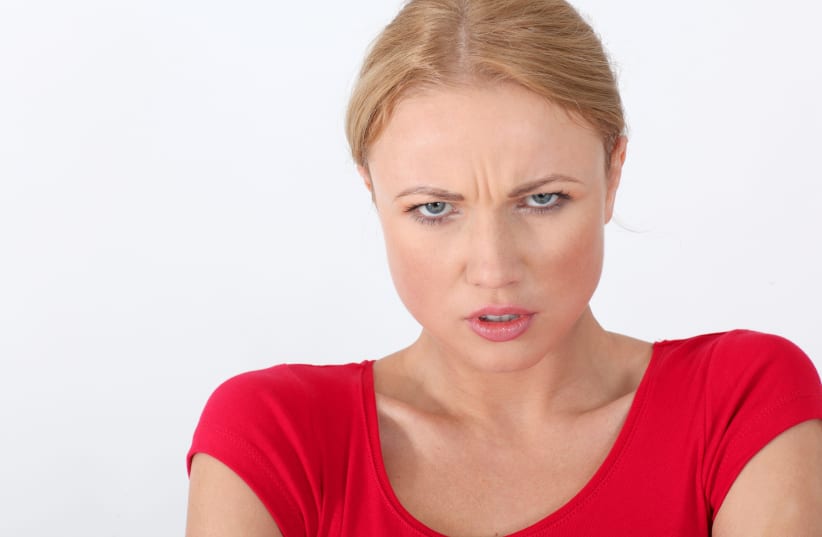 Woman in red shirt with angry look (photo credit: INGIMAGE PHOTOS)