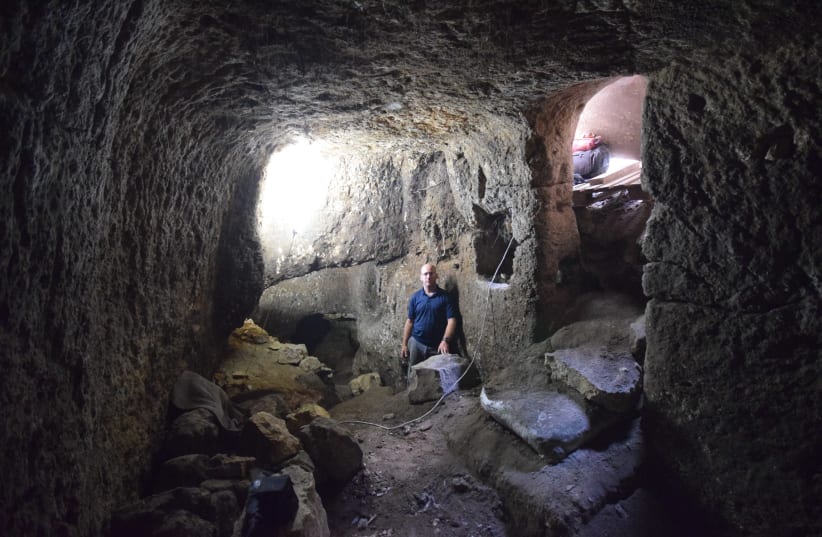 An inspector from the Antiquities Authority inside the plundered caves. (photo credit: COURTESY OF IAA)