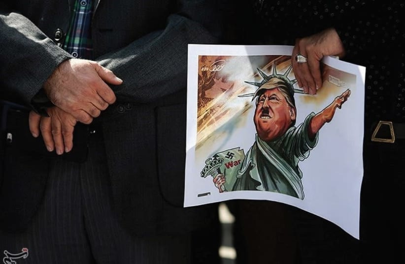 An Iranian student holds a caricature of US President Donald Trump during a protest against Trump’s latest speech on Iran, in Tehran. (photo credit: REUTERS)