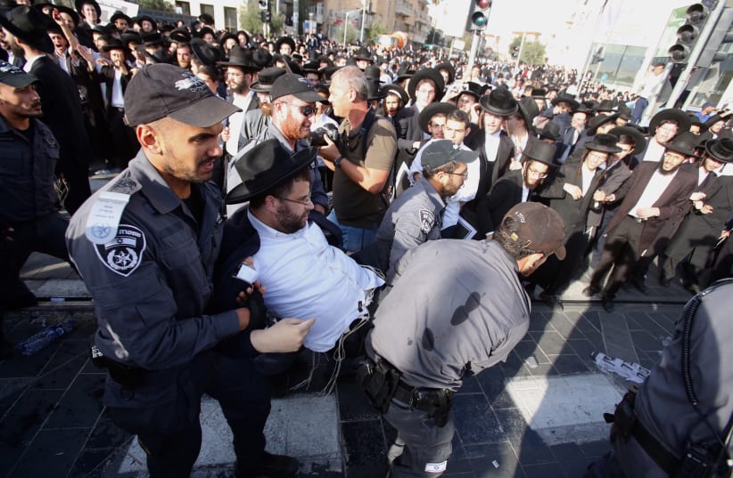 Police arrest a haredi man protesting against the drafting of ultra-Orthodox into the IDF, October 2017 (photo credit: MARC ISRAEL SELLEM/THE JERUSALEM POST)