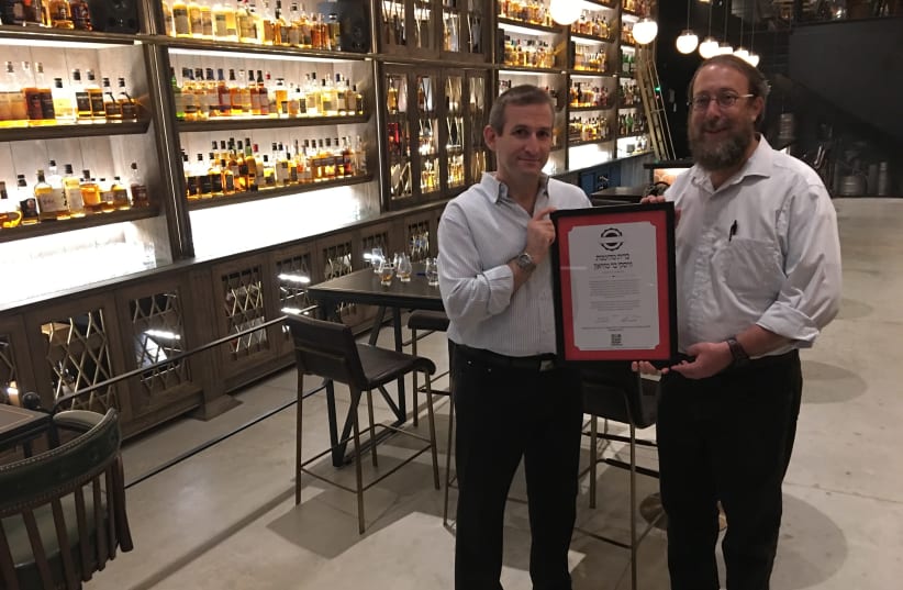 Hashgacha Pratit founder Rabbi Aharon Leibowitz (right) presenting a supervision certificate to the Whisky Bar Museum in Tel Aviv.  (photo credit: HASHGACHA PRATIT)