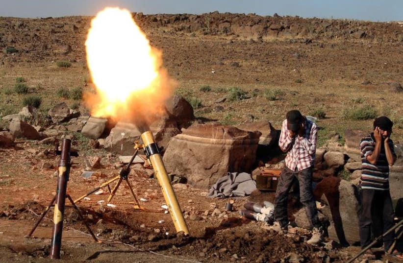 Rebel fighters fire mortar shells towards forces loyal to Syria's President Bashar Assad in Quneitra province, bordering the Golan Heights, Syria June 24, 2017. (photo credit: ALAA AL-FAKIR / REUTERS)