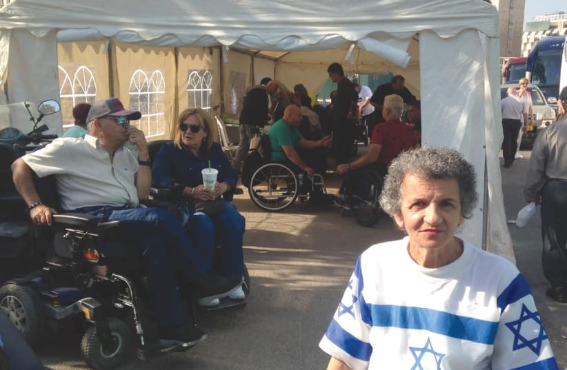 Demonstrators from 15 groups representing people with disabilities gather in their protest tent outside of the Knesset in Jerusalem yesterday. (photo credit: SARAH LEVI)