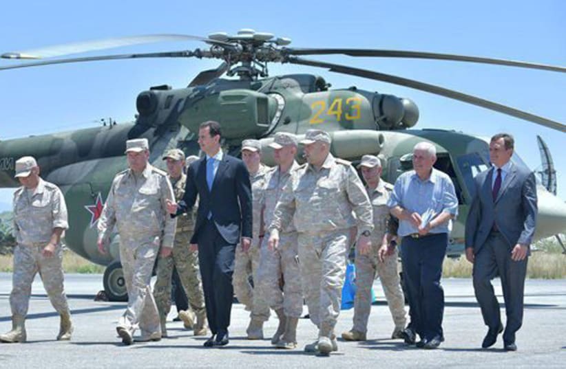 Syria's President Bashar Assad visits a Russian air base at Hmeymim, in western Syria in this handout picture posted on SANA on June 27, 2017, Syria. (photo credit: SANA/HANDOUT VIA REUTERS)