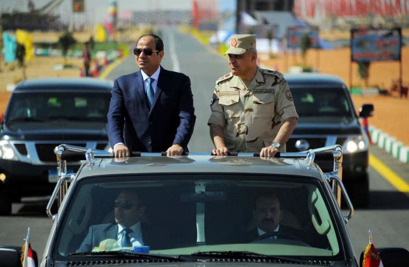Egyptian President Abdel Fattah al-Sisi (L) rides a vehicle with Egypt's Minister of Defense Sedki Sobhi during a presentation of combat efficiency and equipment of the armed forces in Suez, Egypt, October 29, 2017 in this handout picture courtesy of the Egyptian Presidency. (photo credit: THE EGYPTIAN PRESIDENCY/HANDOUT VIA REUTERS)