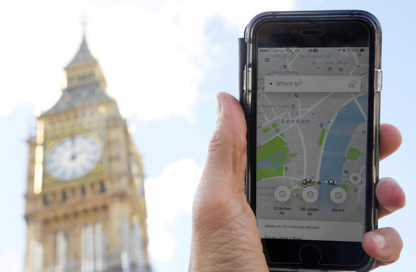 A photo illustration shows the Uber app on a mobile telephone, as it is held up for a posed photograph in central London, Britain September 22, 2017. (photo credit: REUTERS)