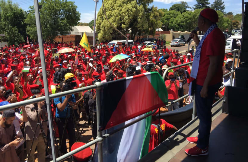 EFF leader Julius Malema addresses anti-Israel protesters on Thursday as a Hezbollah flag flies in the background, outside the Israeli Embassy in South Africa (photo credit: COURTESY TWITTER)