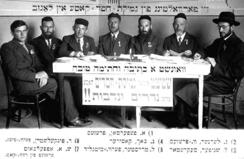 The photograph of a meeting of the Executive Committee of the Gemillus Chasodim (Help for the Needy) Fund of Lagow that appears on the back of a New Year's greeting postcard circa 1937 (photo credit: Courtesy)