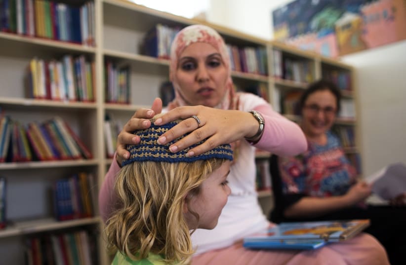 Alia Tunisi, a school teacher, and one of her students at Jerusalem's Hand in Hand Arab-Jewish bilingual school. (photo credit: RONEN ZVULUN / REUTERS)
