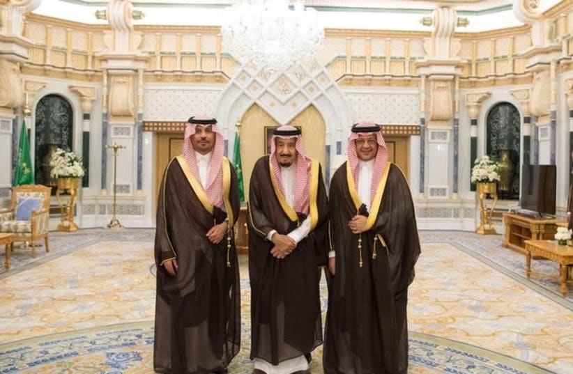 Saudi King Salman bin Abdulaziz Al Saud poses for a photo with National Guard Minister Khaled bin Ayyaf and Economy Minister Mohammed al-Tuwaijri during a swearing-in ceremony in Riyadh, Saudi Arabia, November 6, 2017.  (photo credit: SAUDI PRESS AGENCY/HANDOUT VIA REUTERS)