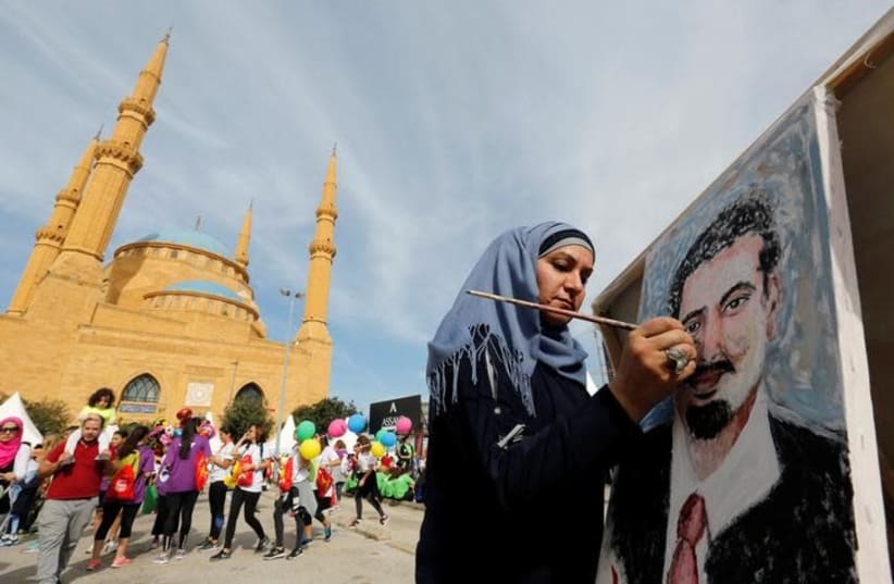 Youmn Ahmad, a Lebanese artist, paints a portrait of Lebanon's Prime Minister Saad al-Hariri, who has resigned from his post, during the annual Beirut Marathon, in Beirut Lebanon November 12, 2017 (photo credit: REUTERS/JAMAL SAIDI)