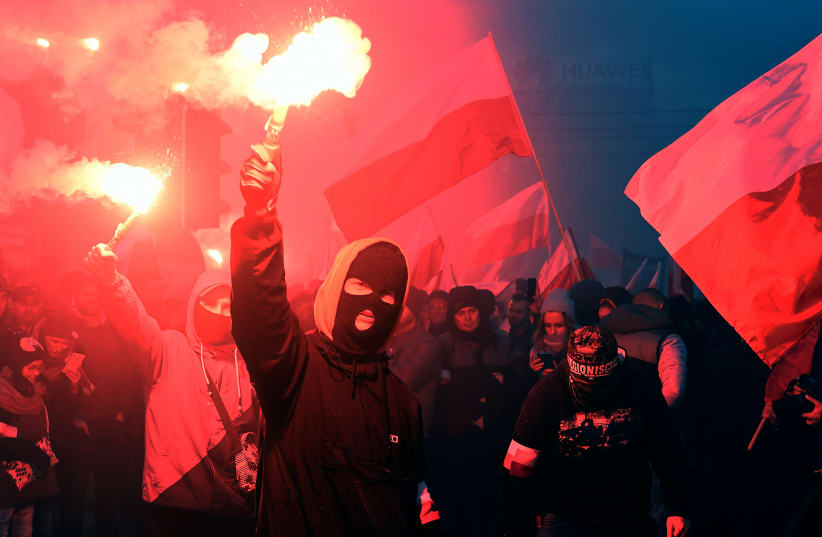 Demonstrators burn flares and wave Polish flags during the annual march to commemorate Poland's National Independence Day in Warsaw (photo credit: AFP PHOTO / JANEK SKARZYNSKI)