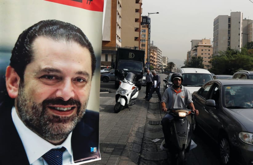 CARS PASS next to a poster depicting Saad Hariri in Beirut earlier this week. Hariri resigned as Lebanon’s prime minister on November 4 (photo credit: REUTERS/MOHAMED AZAKIR)