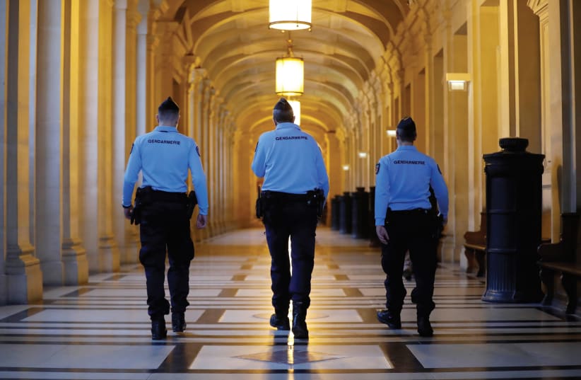 FRENCH GENDARMES walk in the corridors of a Paris courthouse before the verdict in the trial of Abdelkader Merah, brother of gunman Islamist militant Mohammed Merah, who killed 7 people in 2012. (photo credit: REUTERS)
