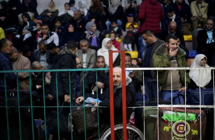 Palestinians wait for travel permits to cross into Egypt, for the first time after Hamas ceded Rafah border crossing to the Palestinian Authority, in Khan Younis in the southern Gaza Strip November 18, 2017 (photo credit: REUTERS/IBRAHEEM ABU MUSTAFA)