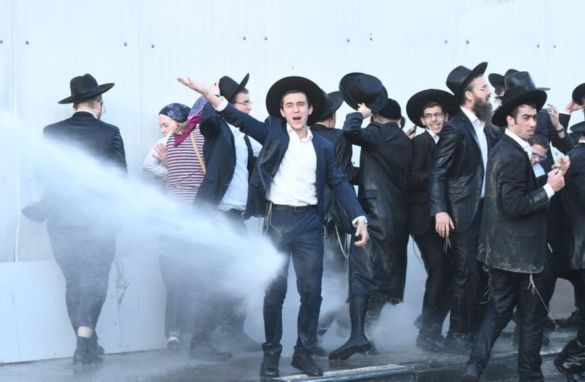 Ultra-Orthodox protestors of the draft are sprayed with water canons in Bnei Brak (photo credit: AVRAHAM SASSONI)