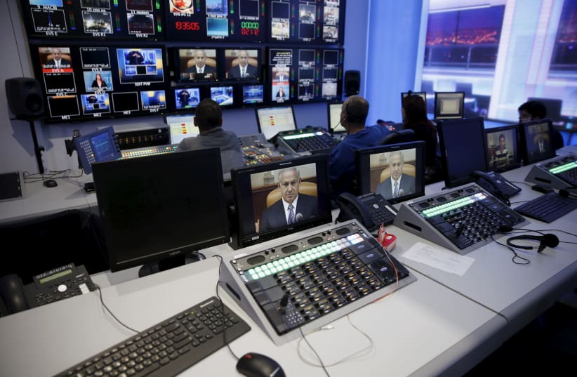 Prime Minister Benjamin Netanyahu is seen on monitors in Channel 10's control room (photo credit: RONEN ZVULUN / REUTERS)