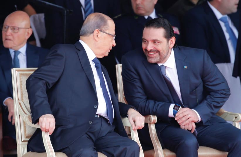 Saad al-Hariri talks with Lebanese President Michel Aoun while attending a Lebanese Independence Day military parade (photo credit: MOHAMED AZAKIR / REUTERS)