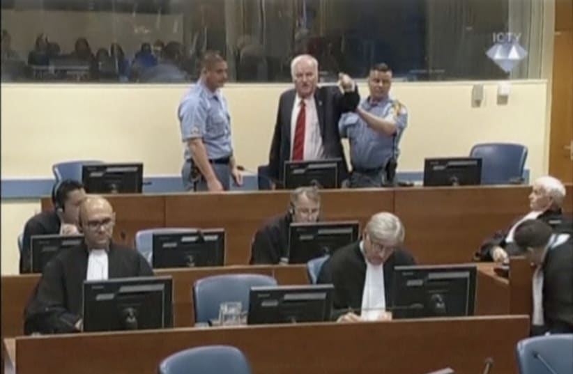 Ex-Bosnian Serb wartime general Ratko Mladic reacts in court at the International Criminal Tribunal for the former Yugoslavia (ICTY) in the Hague, Netherlands in this still image taken from a video released by the International Criminal Tribunal for the former Yugoslavia (ICTY), November 22, 2017 (photo credit: REUTERS)