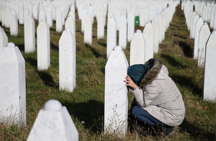 A woman reacts near a grave of her family members in the Memorial centre Potocari near Srebrenica, Bosnia and Herzegovina, after the court proceedings of former Bosnian Serb general Ratko Mladic, November 22, 2017 (photo credit: REUTERS/ DADO RUVIC)