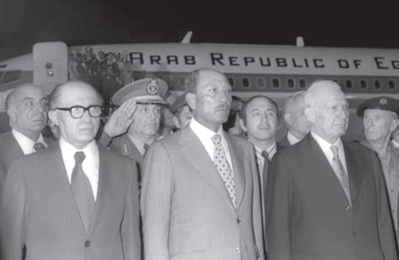 Egyptian President Anwar Sadat and Israeli Prime Minister Menachem Begin stand together at Ben Gurion Airport after Sadat’s arrival on November 19, 1977. (photo credit: GPO)