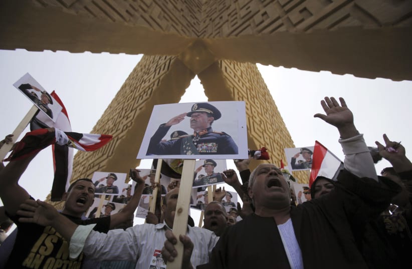 Supporters of the army hold posters of Egyptian president Anwar Sadat at his tomb in Cairo. (photo credit: REUTERS)