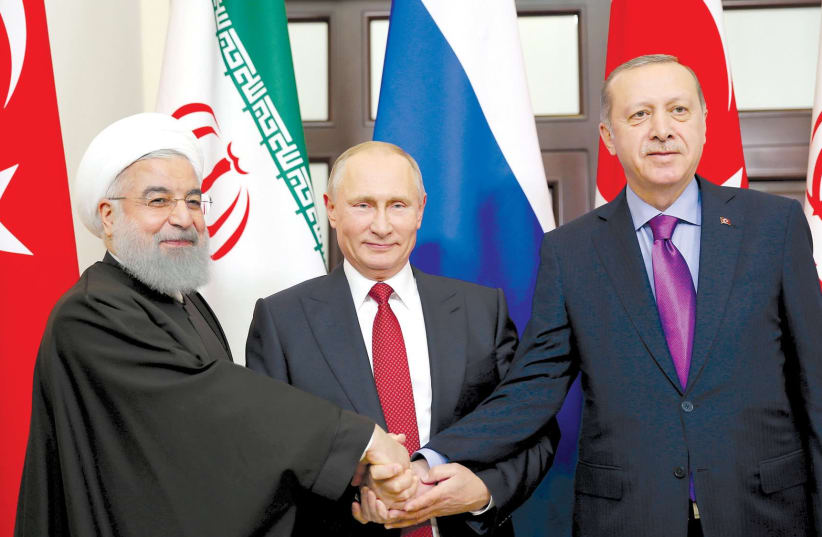 PRESIDENT HASSAN ROUHANI of Iran (left) joins hands with Russian President Vladimir Putin (center) and Turkey’s President Tayyip Erdogan in Sochi, Russia (photo credit: REUTERS)