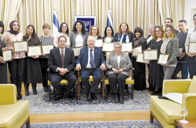 PRESIDENT REUVEN RIVLIN is flanked by his wife, Nechama, and businessman Uri Ben-Ari on at the President’s Residence in Jerusalem as they pose with outstanding special education teachers recognized by Ben-Ari’s Athena Fund for their innovative teaching technologies. (photo credit: MARK NEYMAN/GPO)