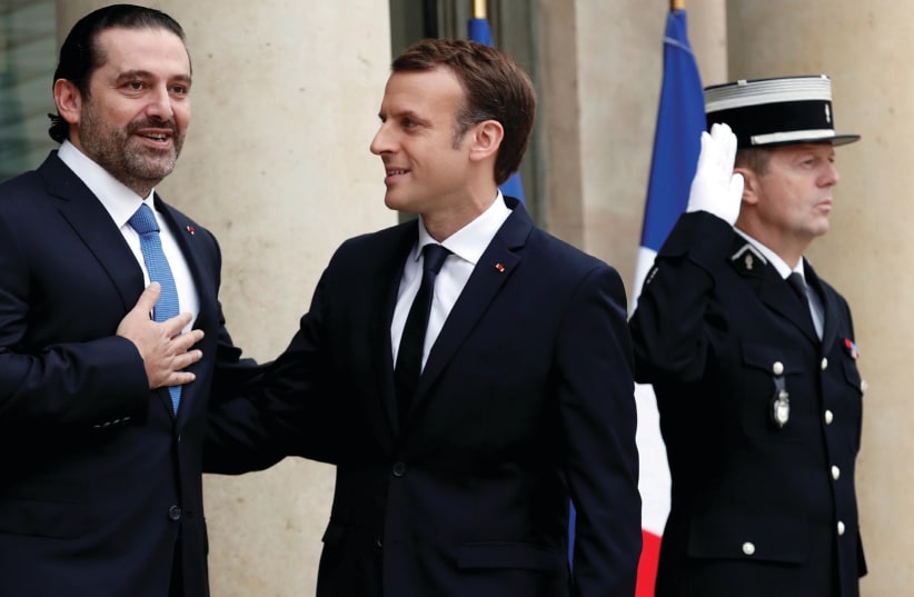 French President Emmanuel Macron (center) welcomes Lebanese Prime Minister Saad al-Hariri on the steps of the Elysee Palace in Paris, on November 18 (photo credit: BENOIT TESSIER /REUTERS)