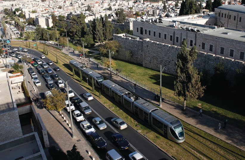 Cars come to a standstill as the light rail passes outside the walls of Jerusalem’s Old City (photo credit: RONEN ZVULUN/REUTERS)