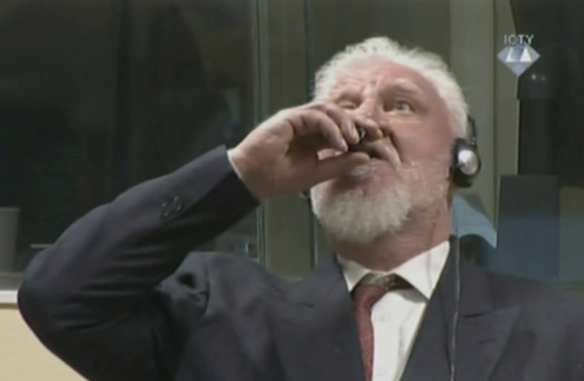 A wartime commander of Bosnian Croat forces, Slobodan Praljak, is seen during a hearing at the U.N. war crimes tribunal in the Hague, Netherlands, November 29, 2017. (photo credit: ICTY VIA REUTERS TV)