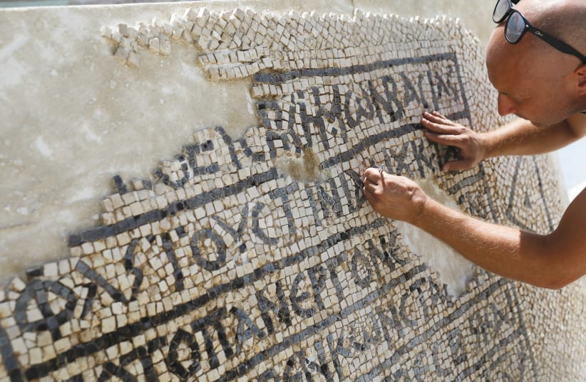 A CONSERVATIONIST works at the Rockefeller Museum in Jerusalem on a 1,500-year-old mosaic floor bearing a Greek writing, discovered near Damascus Gate in Jerusalem’s Old City. (photo credit: REUTERS)