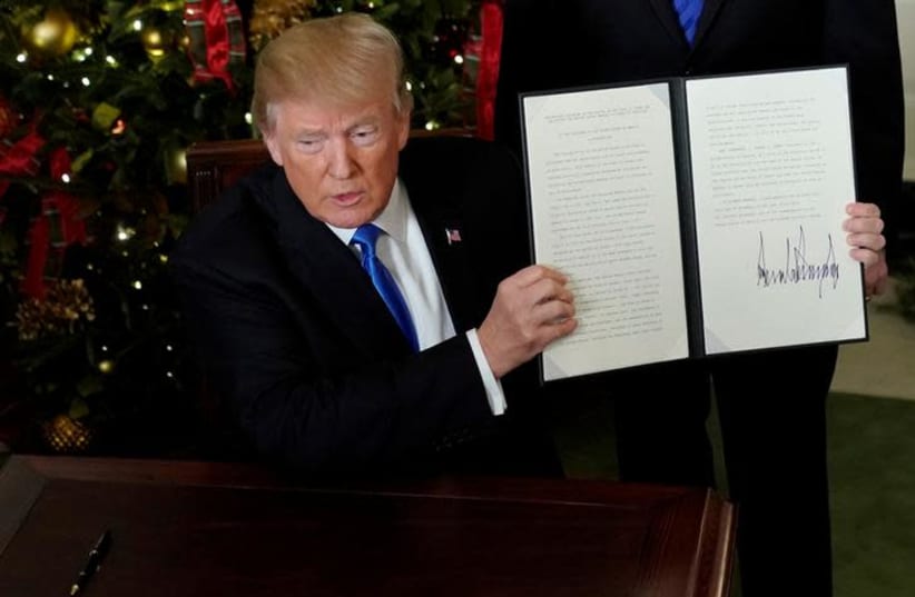 US President Donald Trump displays an executive order after he announced the U.S. would recognize Jerusalem as the capital of Israel, in the Diplomatic Reception Room of the White House in Washington, US December 6, 2017. (photo credit: JONATHAN ERNST / REUTERS)