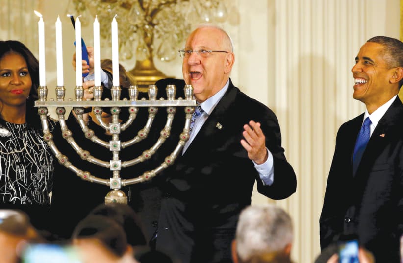 PRESIDENT Reuven Rivlin (center) lights a hanukkia as he joins former US president Barack Obama and  rst lady Michelle Obama for a Hanukka reception at the White House in 2015 (photo credit: JONATHAN ERNST / REUTERS)
