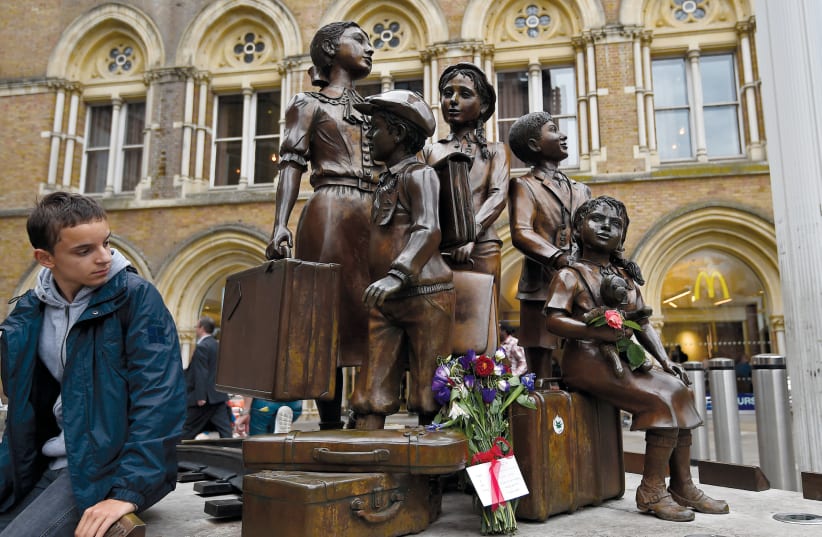 A TRAVELER looks toward the ‘Kindertransport’ memorial in London (photo credit: TOBY MELVILLE/REUTERS)
