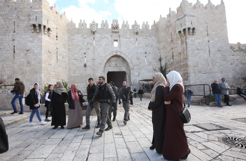 Muslim women and Israeli security forces outside the Damascus Gate in the Old City of Jerusalem. (photo credit: MARC ISRAEL SELLEM)