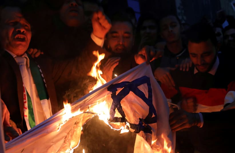 People shout slogans against Israel while burning a makeshift Israeli flag during a protest against Trump's Jerusalem declaration, in front of the Syndicate of Journalists in Cairo, Egypt December 7, 2017.  (photo credit: MOHAMED ABD EL GHANY/REUTERS)