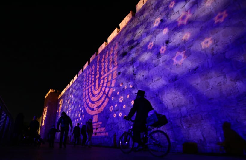 The walls of Jerusalem’s Old City are illuminated with symbols of the Hanukka holiday. (photo credit: MARC ISRAEL SELLEM/THE JERUSALEM POST)